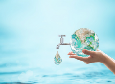 Hands holding earth with a water tap