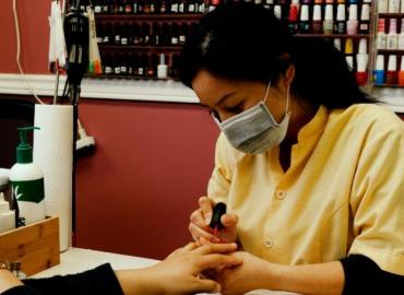 Jackie Liang at work, painting nails in a Toronto salon.